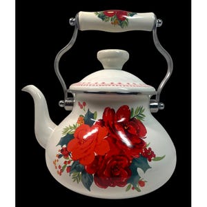 May include: White enamel tea kettle with a floral design featuring large red roses, green leaves, and red berries. The handle and lid knob are white with a floral pattern. The kettle has a silver-colored metal handle and spout.