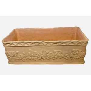 May include: A rectangular, beige planter with a floral rose design. The planter has a scalloped trim along the top edge and a light pink interior. The exterior features a repeating pattern of roses and leaves.