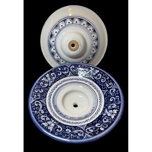 May include: Two ceramic ceiling light fixtures. The top fixture is white with a blue geometric pattern. The bottom fixture is white with a blue floral design and the text "Dipinta a Mano" and "Deruta, Italia".