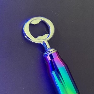 Könnte beinhalten: Ein regenbogenfarbener Flaschenöffner mit silberner Kappe und einem strukturierten Griff.