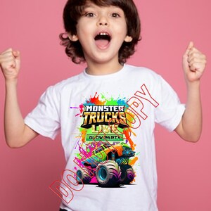 Może przedstawiać: Biała koszulka z kolorową grafiką przedstawiającą monster trucka. Grafika zawiera tekst "Monster Trucks Live Glow Party".