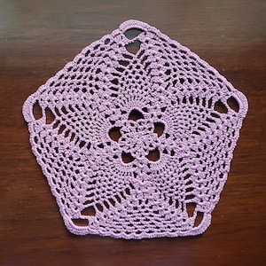 May include: A delicate lavender crochet doily with a floral design. The doily is made with a fine thread and has a delicate, lacy appearance.