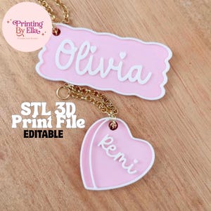 Op de afbeelding: Roze en witte gepersonaliseerde naamlabels met gouden kettingbevestigingen. Eén label is rechthoekig met de naam "Olivia", de andere is hartvormig met de naam "Remi". De afbeelding bevat ook de tekst "STL 3D Print File EDITABLE".