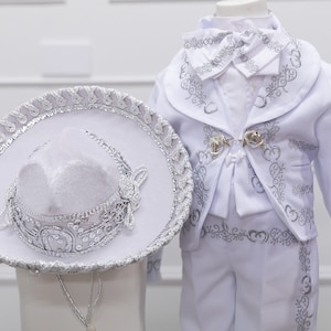 Traje de charro que incluye sombrero con detalles plateados y detalles dorados.