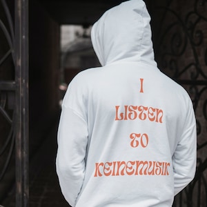 Pode incluir: Um moletom branco com o texto "I listen to keine musik" impresso em laranja nas costas.