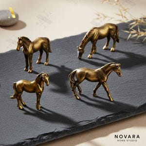 May include: Four antique gold-colored horse figurines in various poses are displayed on a dark gray surface. The horses are detailed with realistic features, and the overall aesthetic is vintage. The Novara Home Studio logo is visible in the bottom right corner.