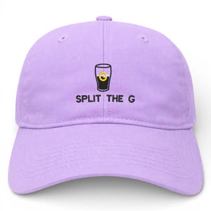 May include: A light purple baseball cap with a curved brim. The cap features a graphic of a black pint glass with a gold "G" inside and the text "SPLIT THE G" in black letters.