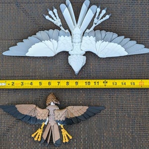May include: Two bird models, one white and one brown, with detailed wings and legs. The white bird is larger and has a wingspan of approximately 17 inches. The brown bird is smaller and has a wingspan of approximately 10 inches.