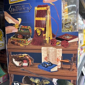 May include: A "Make It Mini" Back to Hogwarts miniature set. The set includes a miniature scarf, book, chest, and other accessories. The box has the number 12 on it.