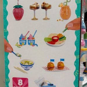 Pode incluir: Uma exibição colorida de miniaturas de comida de café, incluindo sobremesas, bebidas e pratos salgados. O conjunto apresenta uma bebida em forma de morango, taças de sorvete, hambúrgueres e uma lancheira. O texto "MAKE IT MINI CAFE" é visível.