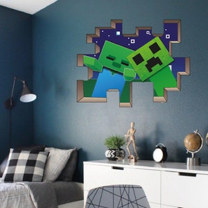 May include: A green Minecraft Creeper and Zombie character wall decal. The characters are breaking through a pixelated wall. The decal is on a blue wall in a bedroom with a bed, nightstand, and lamp.