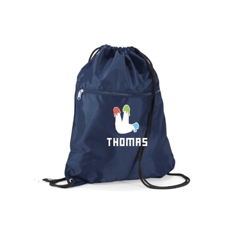 Peut inclure: Sac de sport bleu marine avec cordon de serrage, orn&eacute; d'un motif blanc et du nom "THOMAS" en lettres blanches. Le motif repr&eacute;sente une forme blanche avec des coulures de peinture rouge, verte et bleue. Le sac a une poche zipp&eacute;e et une fermeture &agrave; cordon noire.