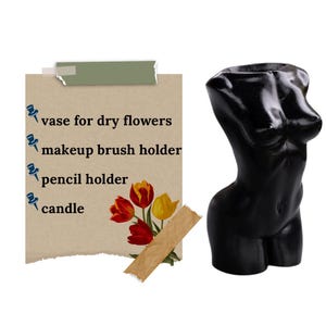 May include: Black, female-shaped vase with a smooth, glossy finish. The vase is shown with a list of uses: vase for dry flowers, makeup brush holder, pencil holder, and candle.