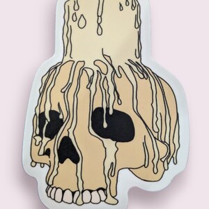 May include: A white skull with dripping wax, resembling a candle. The skull is outlined in black and has black eye sockets.