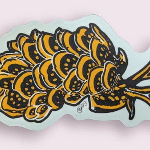 May include: A black and yellow sticker with a stylized illustration of a sea slug. The slug has a rounded body with a series of overlapping, scalloped edges. The slug has a long, thin tail that curls up at the end. The sticker has a white background.