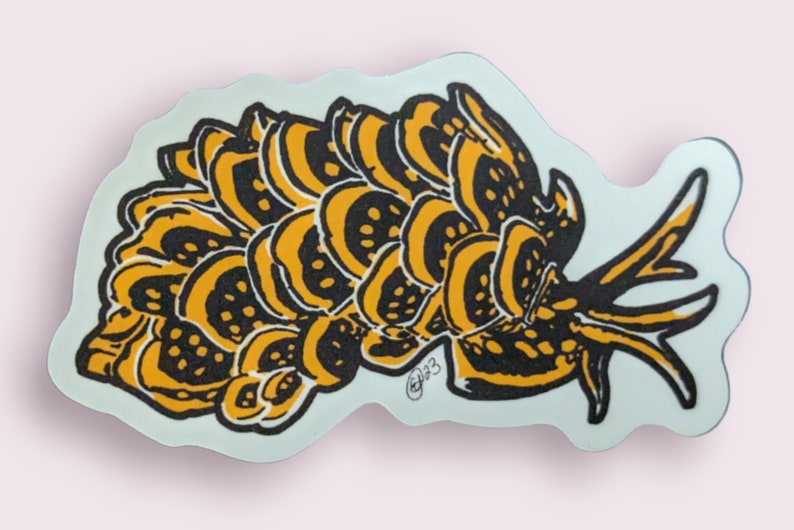 May include: A black and yellow sticker with a stylized illustration of a sea slug. The slug has a rounded body with a series of overlapping, scalloped edges. The slug has a long, thin tail that curls up at the end. The sticker has a white background.