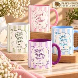 May include: Four ceramic mugs with vertical stripes in pastel green, pink, blue, and purple. Each mug features a decorative frame with text: Faith Over Fear, Saved by Grace, God's Timing Is Perfect, and Blessed & Highly Favored with names.