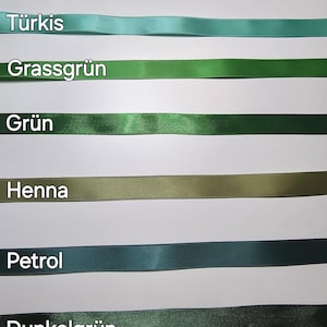 Pu&ograve; includere: Una selezione di nastri di raso in varie tonalit&agrave; di verde e blu, tra cui acqua, turchese, verde erba e verde scuro. Ogni nastro &egrave; etichettato con il nome del colore in testo bianco. I nastri sono disposti orizzontalmente su uno sfondo bianco.