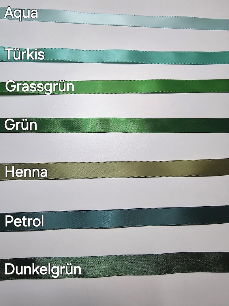 Pu&ograve; includere: Una selezione di nastri di raso in varie tonalit&agrave; di verde e blu, tra cui acqua, turchese, verde erba e verde scuro. Ogni nastro &egrave; etichettato con il nome del colore in testo bianco. I nastri sono disposti orizzontalmente su uno sfondo bianco.