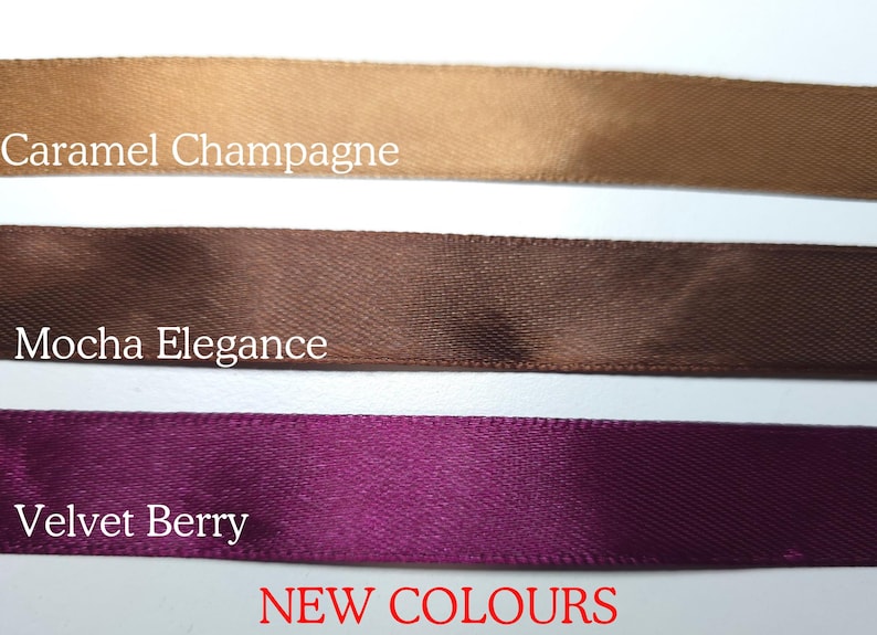 Pu&ograve; includere: Primo piano di tre nastri di raso nei colori Caramel Champagne, Mocha Elegance e Velvet Berry. Il testo "NEW COLOURS" &egrave; visualizzato in rosso. Adatto per lavori artigianali e decorazioni.