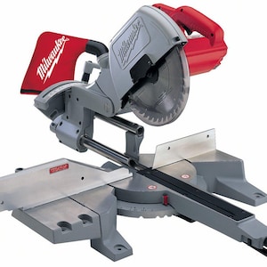 May include: A gray and red Milwaukee miter saw. The saw has a circular blade, a red handle, and a red dust bag with the Milwaukee logo. The base has a measurement scale. The saw is designed for cutting wood and other materials.