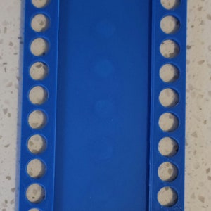 May include: A blue plastic knitting loom with 18 pegs on each side. The loom is designed for knitting flat projects.