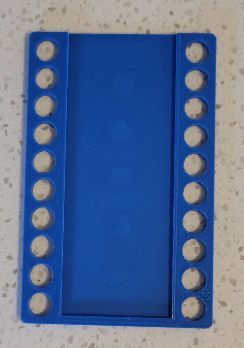 May include: A blue plastic knitting loom with 18 pegs on each side. The loom is designed for knitting flat projects.