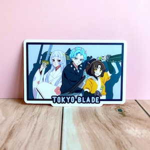 May include: A sticker featuring three anime characters with swords. The characters are a woman with white hair, a man with blue hair, and a woman with brown hair. The sticker has a blue border and the text "TOKYO BLADE" at the bottom.