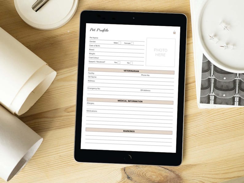 May include: A digital tablet displaying a pet profile form with sections for pet name, date of birth, breed, weight, coat color, vet information, medical information, and markings. The form has a space for a photo of the pet.