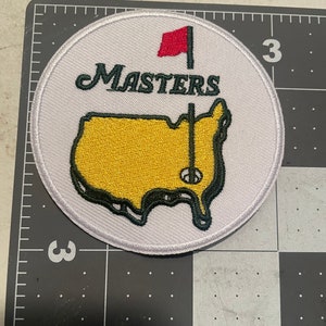 May include: White embroidered patch with a green outline of the United States, a red flag, and the text "Masters" in green.