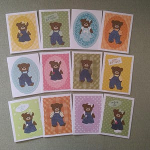 May include: A collection of handmade greeting cards featuring brown teddy bears in various outfits. Each card has a unique background color and design, with some including the text "Happy Birthday" or "Thinking of You".