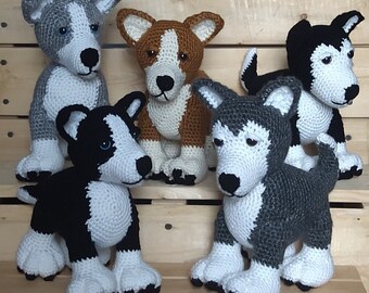 May include: Four crocheted stuffed dog toys. The dogs are a black and white husky, a brown and white husky, a gray and white husky, and a black and white terrier.