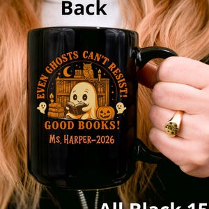 May include: A black 15 oz ceramic mug featuring an orange graphic of a ghost reading a book in a library with an owl, a pumpkin, and the text "EVEN GHOSTS CAN'T RESIST! GOOD BOOKS! MS. HARPER-2026" printed on the front surface of the mug.