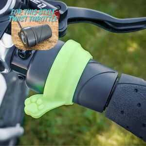 May include: A green motorcycle throttle grip with a paw print design. The text "FOR THIS STYLE TWIST THROTTLE" is visible in the image.