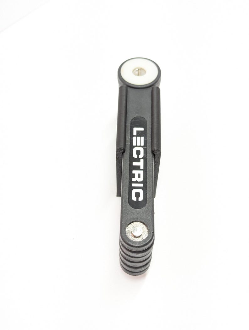 Pu&ograve; includere: Un lucchetto per bici pieghevole nero con la scritta "LECTRIC" stampata in bianco. Il lucchetto &egrave; composto da una serie di barre metalliche collegate e ha un terminale circolare bianco. Il lucchetto &egrave; progettato per proteggere una bicicletta.