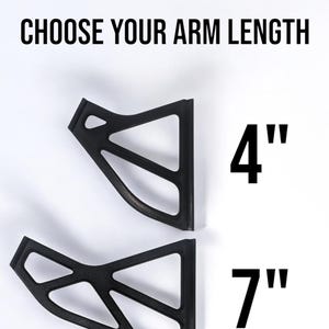 May include: Two black, geometric-shaped brackets with open designs are displayed against a white background. The text "CHOOSE YOUR ARM LENGTH" is above the brackets. One bracket is labeled "4" and the other is labeled "7".