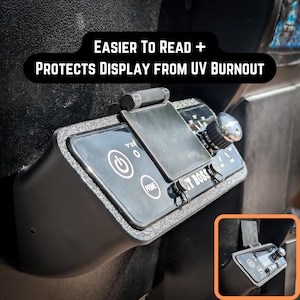 May include: A black, UV-resistant display cover for a car radio. The cover has a textured surface and features a power button, a "Prime" button, and a knob. The text "JT BOSS" is visible on the cover.