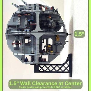 May include: A gray plastic wall mount bracket supporting a spherical building block space station model. The bracket features a lattice design and provides 1.5 inches of wall clearance at the center, as indicated by the text on the image.