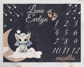 May include: A black and white baby milestone blanket with a cute white dragon illustration. The blanket features a crescent moon, stars, and the text "Luna Evelyn" and "1-12 months".