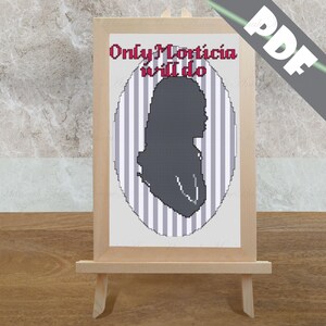 May include: A cross-stitch pattern featuring a silhouette of Morticia Addams from the Addams Family. The pattern is framed and displayed on an easel. The text "Only Morticia will do" is above the silhouette.