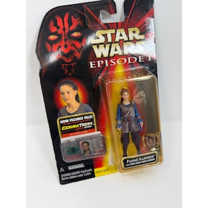 Könnte beinhalten: Star Wars Episode I Actionfigur von Padmé Naberrie in einer transparenten Kunststoffverpackung. Die Figur trägt ein blaues und braunes Outfit. Die Verpackung zeigt das Gesicht von Darth Maul und den Text "Star Wars Episode I". Enthält einen CommTech-Chip.