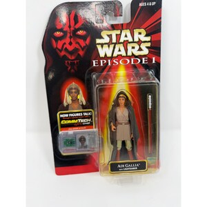 Könnte beinhalten: Star Wars Episode I Adi Gallia Actionfigur in Originalverpackung. Die Figur befindet sich in einer transparenten Kunststoffbox mit einem roten Lichtschwert. Die Verpackung zeigt Darth Maul und den Text "NOW FIGURES TALK! COMMTECH CHIP."