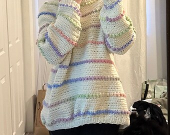 May include: A white crocheted sweater with pastel colored stripes. The sweater has a high neck and long sleeves.