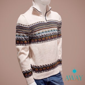 May include: A beige sweater with a multi-colored geometric pattern. The sweater has a mock neck and a zipper.