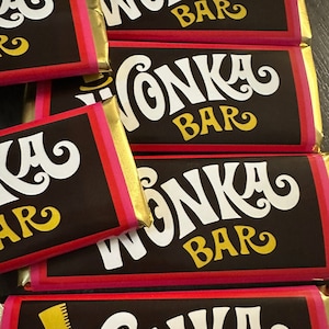 May include: A stack of chocolate bars with a pink and gold wrapper. The bars are labeled "Wonka Bar" in a white, stylized font.