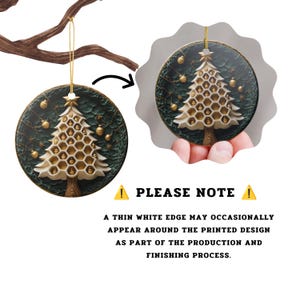 May include: A round ceramic Christmas ornament featuring a white honeycomb-patterned tree on a dark green textured background with gold ornaments. It hangs from a gold string. Text reads: PLEASE NOTE A THIN WHITE EDGE MAY OCCASIONALLY APPEAR AROUND THE PRINTED DESIGN AS PART OF THE PRODUCTION AND FINISHING PROCESS.