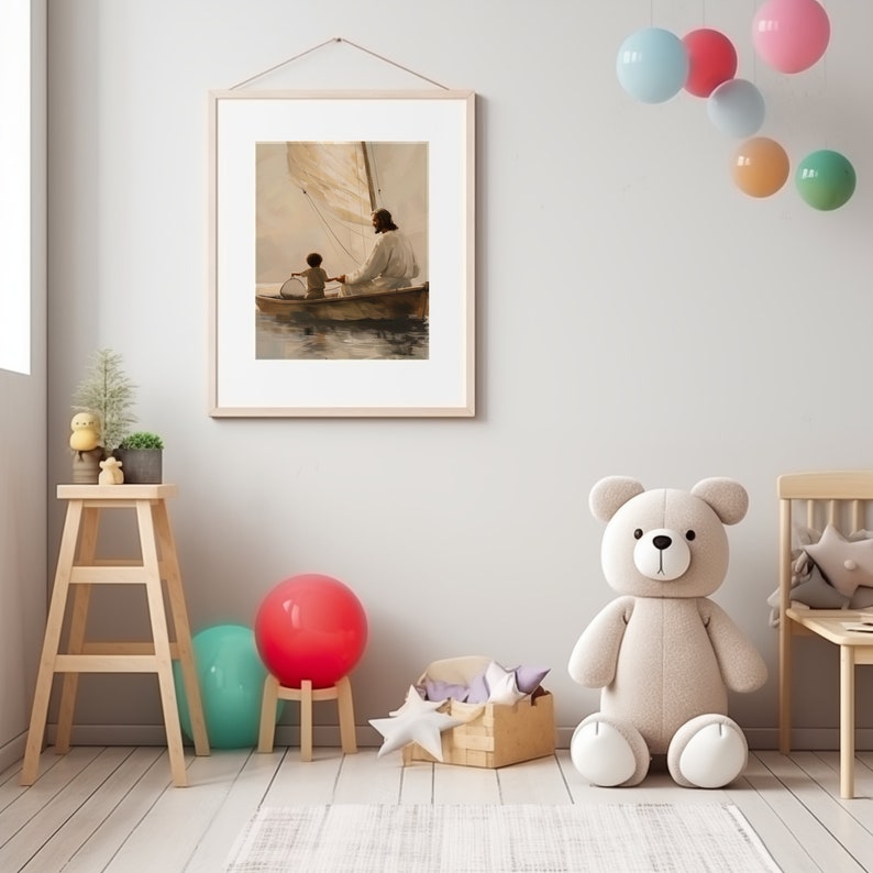 May include: Framed artwork showing a person in white robes with a child in a boat on water. The artwork has a light wood frame and is hanging on a light grey wall. The room features a wooden stool, a large teddy bear, and colourful balloons.