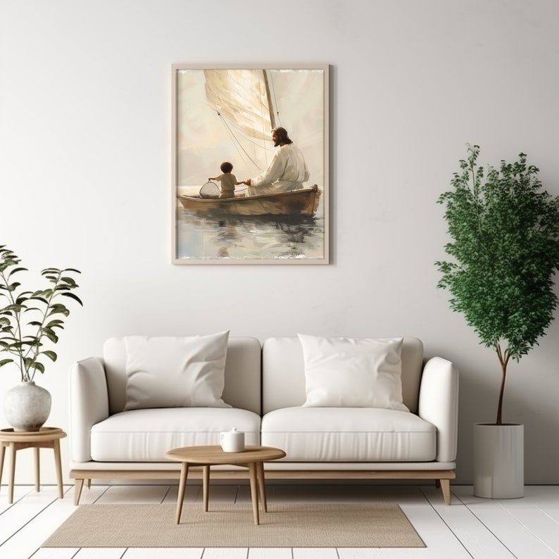 May include: A framed art print showing a boat on water with two figures. One figure, in a white robe, is seated, holding the hand of a child. The sail is a light beige colour, and the artwork has a soft, muted colour palette.
