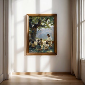 May include: A framed painting depicting Jesus teaching a group of children in a lush green landscape. The painting features a large tree with a thick trunk and a bright blue sky.