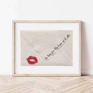 May include: A framed print of a white envelope with a red lipstick kiss and the text "to live for the hope of it all."